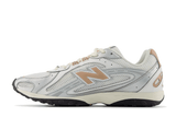 Vista lateral do New Balance New Balance 204L Silver Metallic Flat Taupe Prateado mostrando design do cabedal e logo da marca