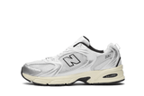 Vista lateral do New Balance New Balance 530 Silver Cream Prateado mostrando design do cabedal e logo da marca