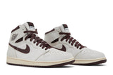 Vista frontal do Jordan Nike A Ma Maniére x Air Jordan 1 Sail and Burgundy mostrando biqueira e costuras